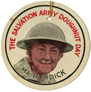 A round paper tag featuring a picture of a woman wearing a helmet. Text reads "The Salvation Army Doughnut Day Ma Burdick"