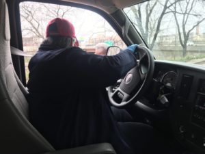 A person sitting in the drivers seat of a cargo van