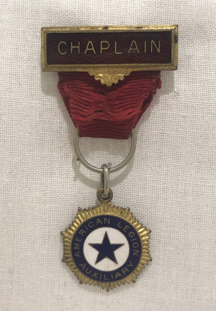 Small medal with pendant and red ribbon signifying wearer was the chaplain of the American Legion Auxiliary