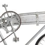 Photograph of the side of a bicycle. The front gears have been strapped in between two top tubes.
