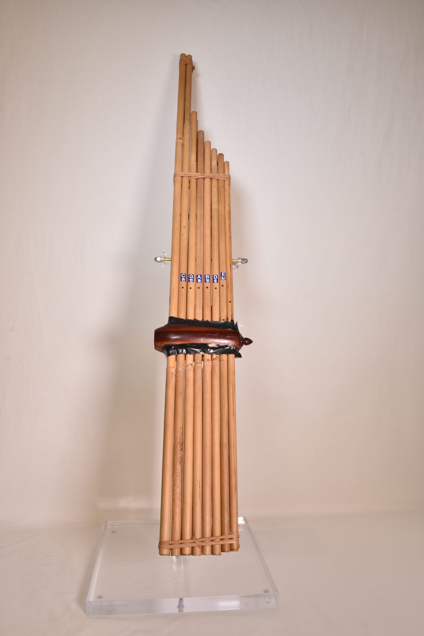 An instrument composted of long reeds bound together with reed. A carved wood piece, where you blow into to play the instrument, is in the center of the reeds.