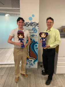 Emmet Burke and Dan Smaczny holding handmade Salvation Army dolls.